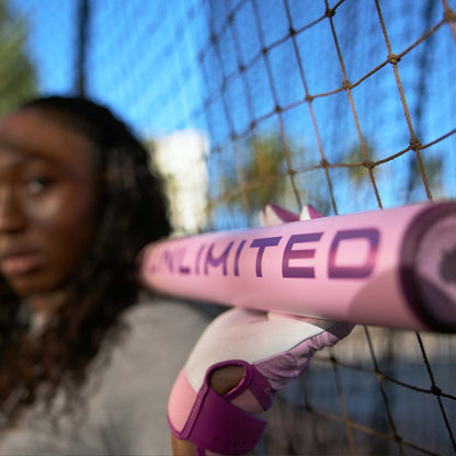 2026 Easton Ghost Unlimited Fastpitch Softball Bat held by a softball player on a fence