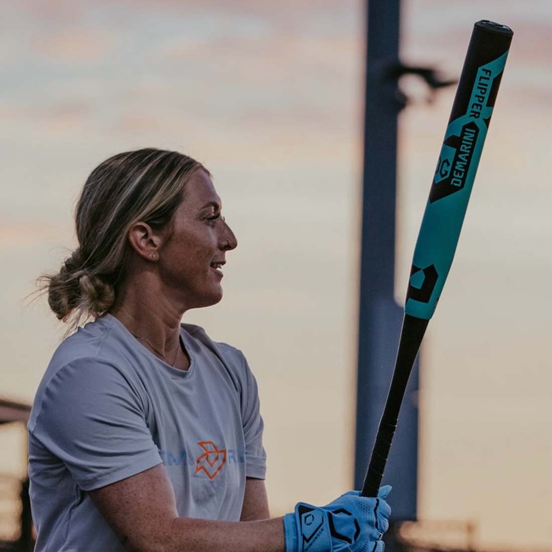 2027 DeMarini Flipper USA slowpitch softball bat 13 inch midload gapped wall barrel ZnX alloy handle held by a female DeMarini pro player