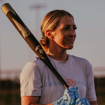 2027 DeMarini Mercy USA slowpitch softball bat 13 inch balanced Stack3d double wall composite barrel being held by a female DeMarini Pro Player