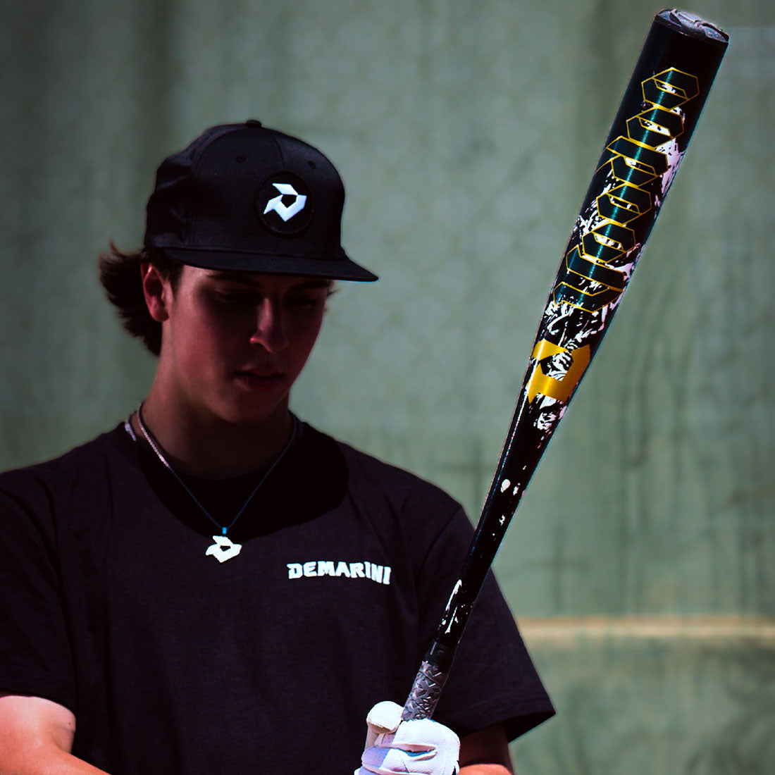 A Baseball Player holding the 2027 DeMarini Voodoo One BBCOR (-3) Baseball Bat in a cage