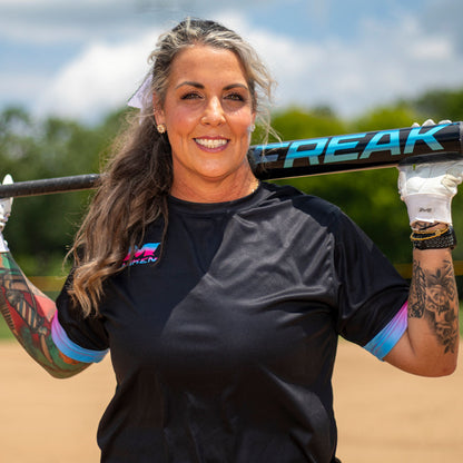 A smiling woman holding the 2026 Miken Freak Black 13" Maxload USA Slowpitch Softball Bat: MSA6FKBLKL