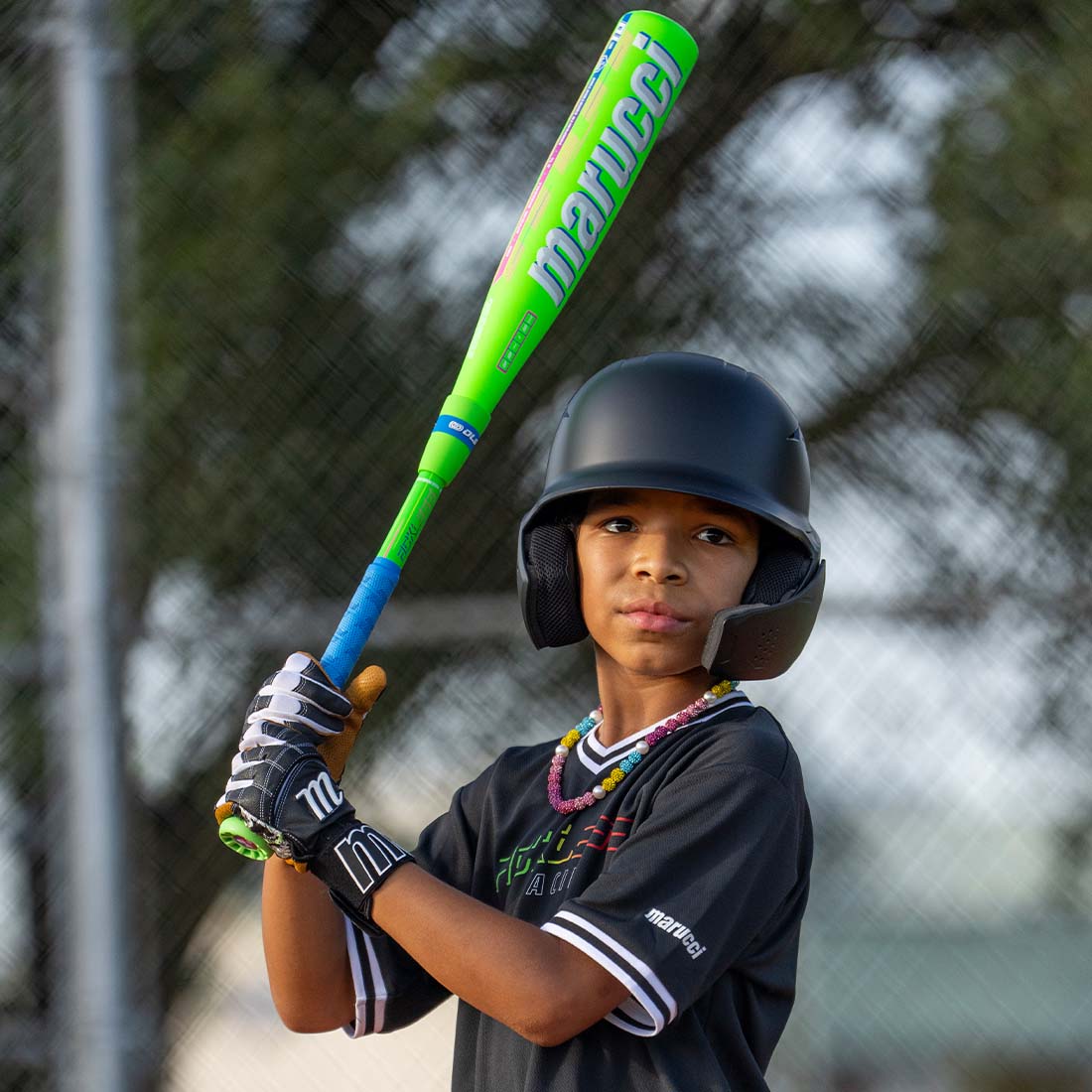 Baseball player holding a Marucci RCKLESS Hybrid USA Baseball Bat on the field.
