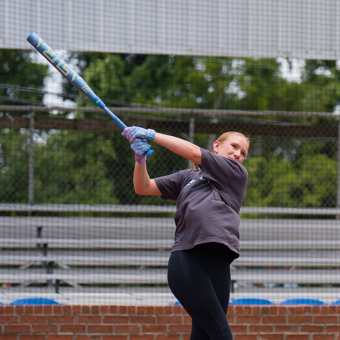 A female softball player swinging the new 2027 Marucci Asura RISE Fastpitch Softball Bat on a field.
