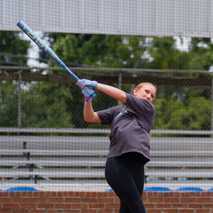 A female softball player swinging the new 2027 Marucci Asura RISE Fastpitch Softball Bat on a field.