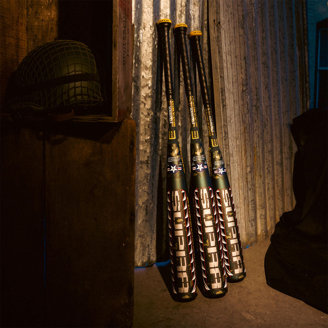 Louisville Slugger SUPRA LE Tigershark USSSA Baseball Bat leaning on a metal wall in a military den